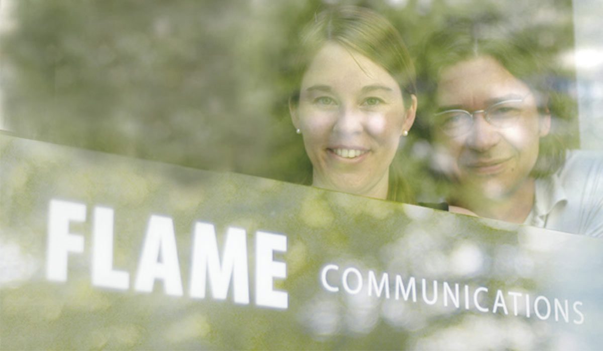 Petra and Boris behind the glass door bearing the flame communications lettering