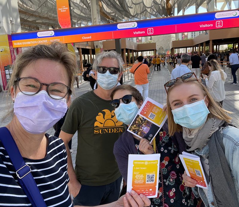 Three members of the flame team wearing face masks at the entrance to the Expo in Dubai